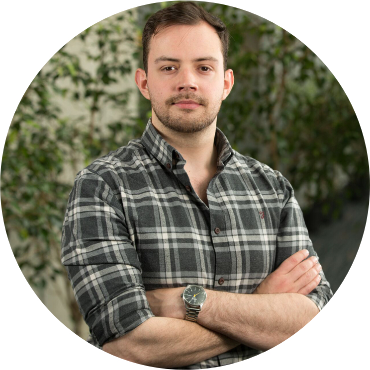 An portrait image of Benjamin Gorman wearing a plaid shirt.