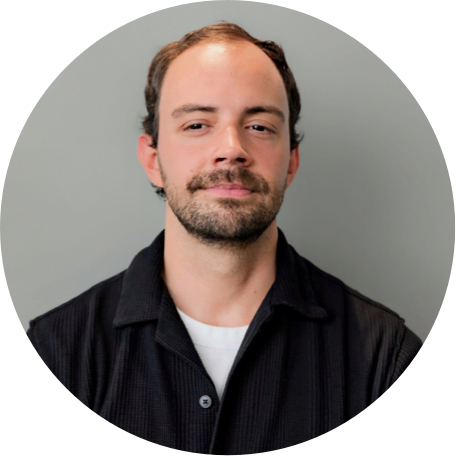 An portrait image of Benjamin Gorman wearing a plaid shirt.